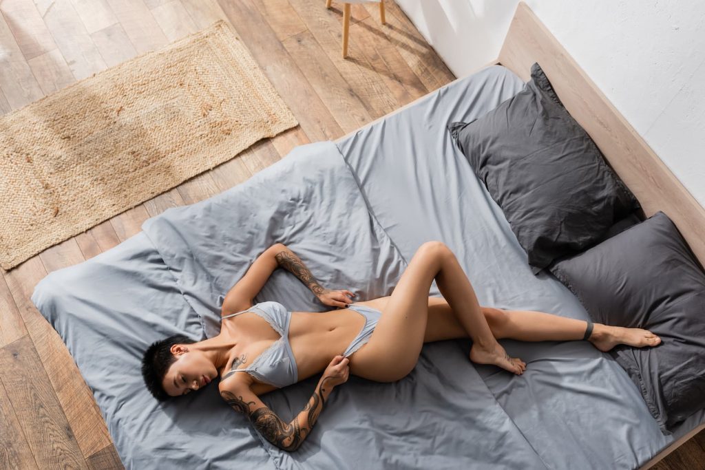 Vista dall'alto di una donna giovane e appassionata con tatuaggi sexy.